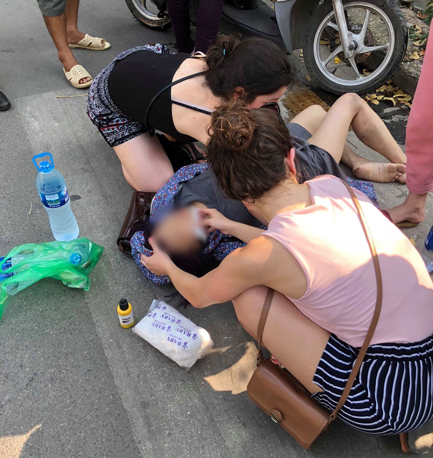 Hà Nội: Nghi say nắng, cô gái tự lao xe vào cột biển báo giao thông được 2 nữ du khách nước ngoài sơ cứu